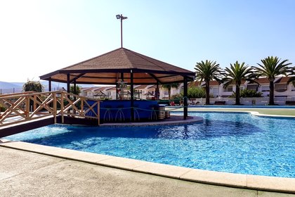 Bassin peu profond, idéal pour les enfants, avec le bar de la piscine en arrière-plan.