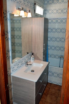 Salle de bain avec WC, vasque et baignoire.